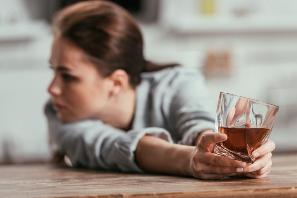 selective focus of sad woman holding whiskey glass 2023 11 27 04 53 44 utc Early signs of addiction in women Early signs of addiction in women,spotting addiction signs,women's addiction symptoms